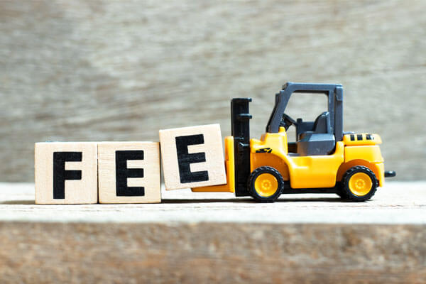 A toy forklift moving blocks that spell "fee".